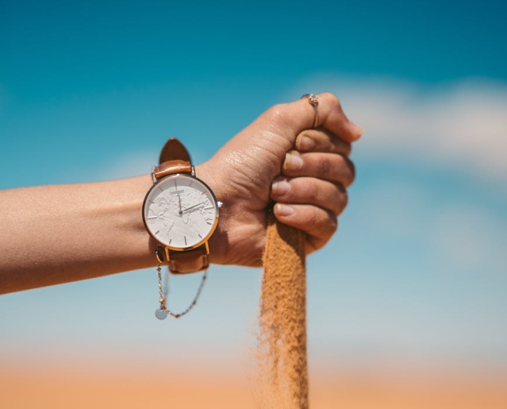 person holding brown rope with silver round analog watch